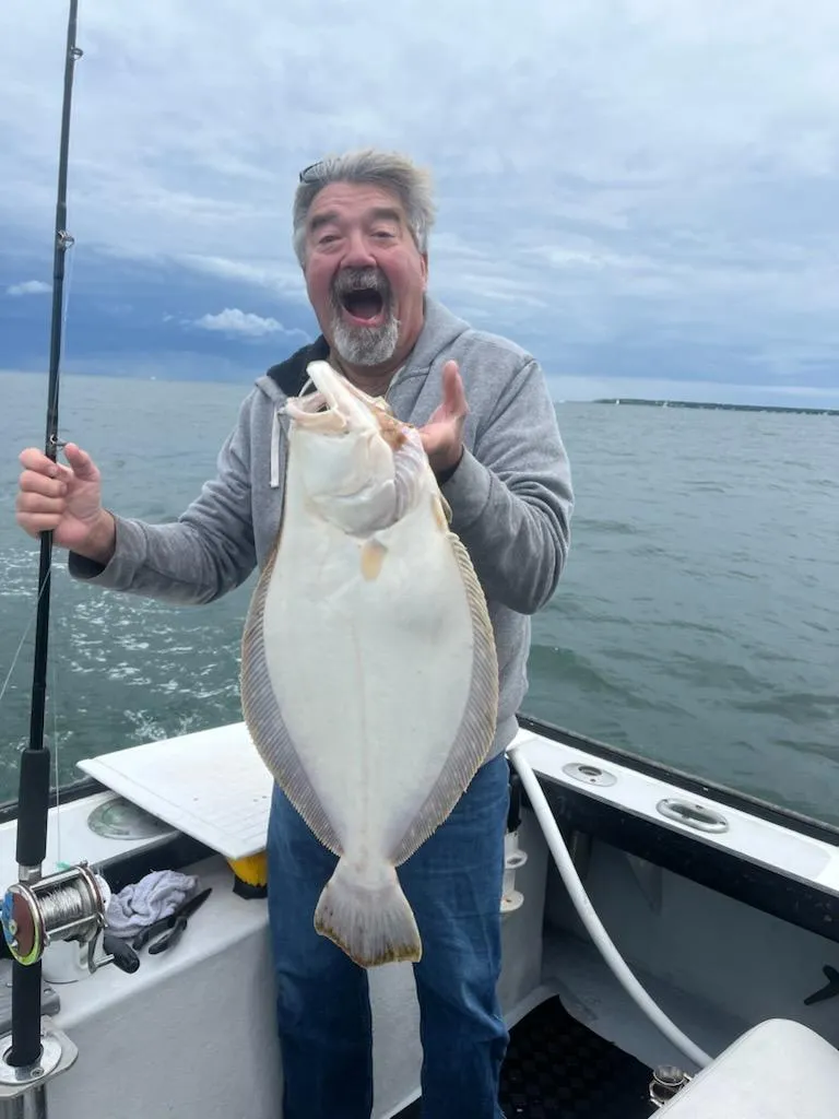 Happy angler holding a keeper fluke caught off Cape Cod