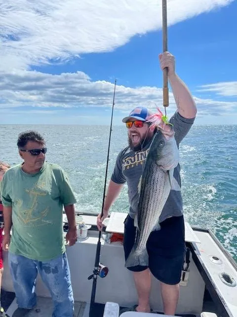 Angler showing off a large striped bass landed with Capt. Jim